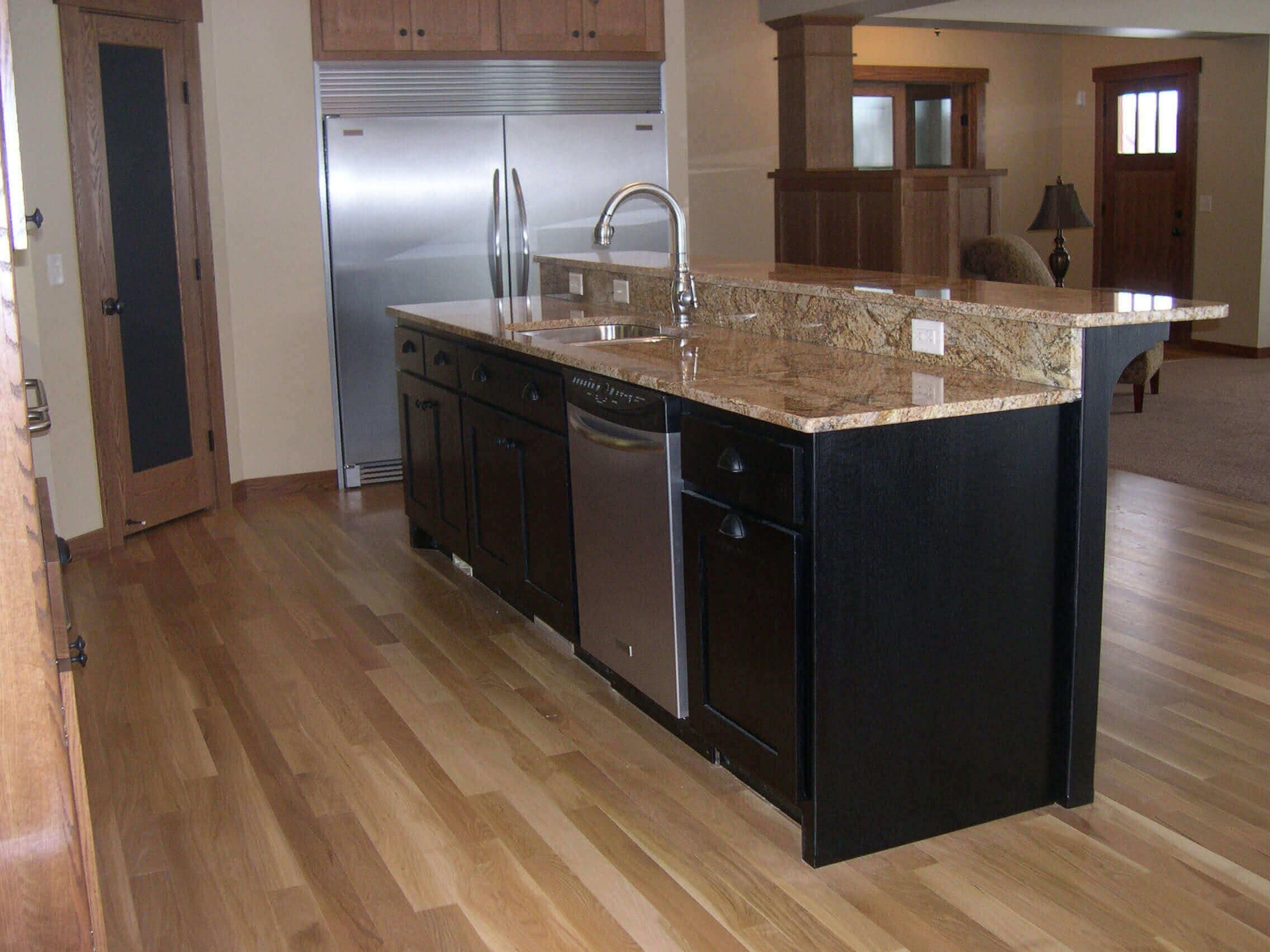 Dark brown kitchen island on a hard wood floor