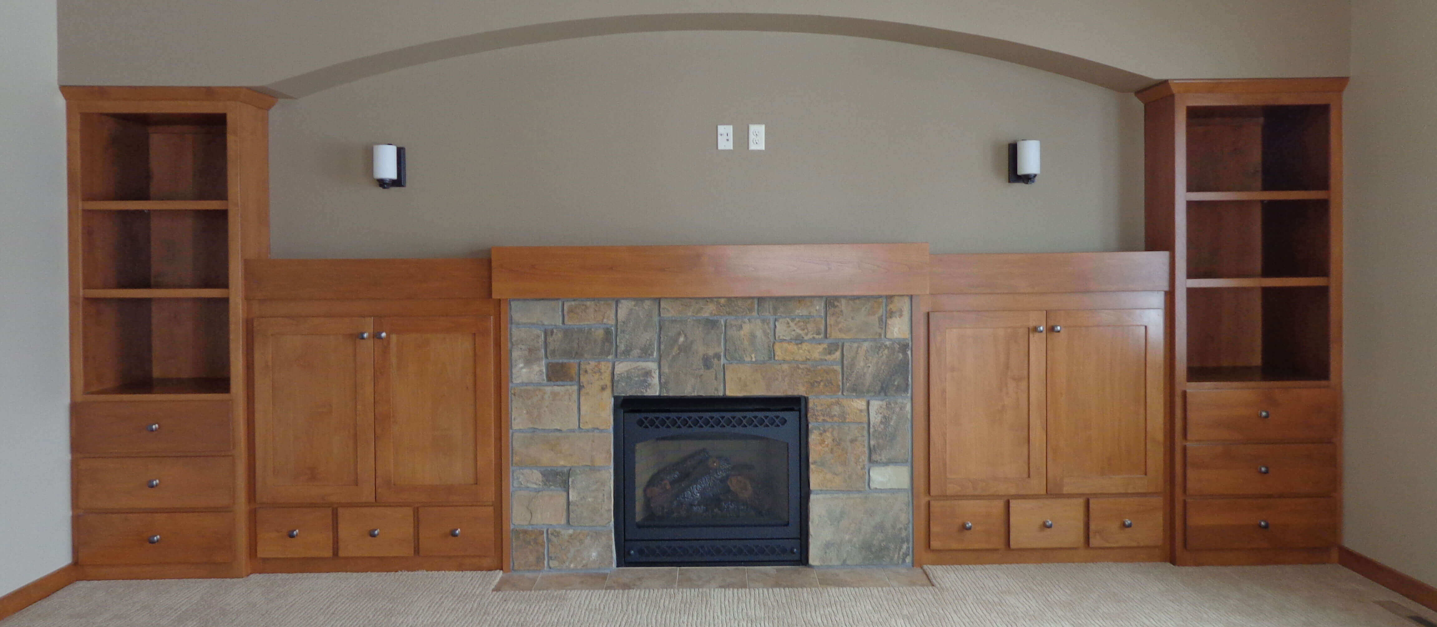 Wood cabinets around a stone fireplace